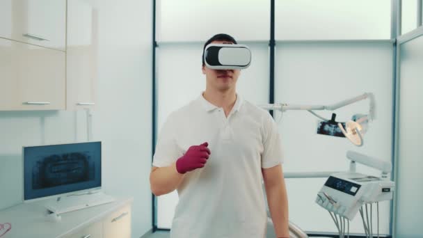 Close-up of multiracial doctor in virtual reality glasses speaking something and gesturing in modern sports lab. — Stock Video