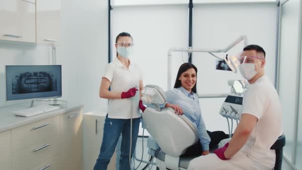 Porträt erfolgreicher Zahnärzte. Zahnarzthelferin und Patientin in der Zahnarztpraxis. Zufriedene lächelnde Patienten zusammen mit Zahnärzten. Porträt erfolgreicher Ärzte. — Stockvideo