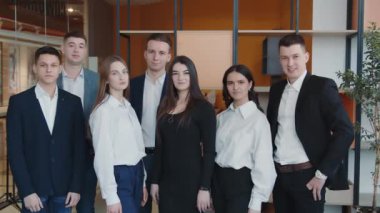 Odada kameraya gülümseyen bir grup öğrencinin portresi..