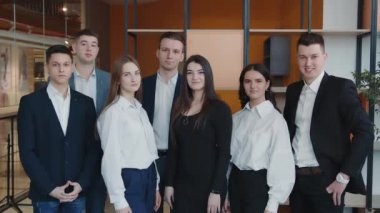 Odada kameraya gülümseyen bir grup öğrencinin portresi..