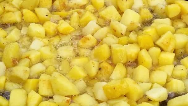 Las patatas se cuecen de cerca en la sartén. Rodajas de patata y aceite caliente. Fondo o textura de patatas fritas en aceite. — Vídeos de Stock