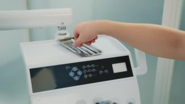 Diş hekimi diş tedavisi için bir araç alır.