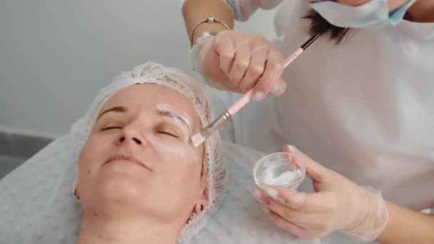 Kosmetyczka wykonuje zabieg liftingu twarzy. Lekarz wstrzykuje lek pod skórę w celu przywrócenia skóry twarzy u osób w podeszłym wieku. Procedura mezoterapii — Wideo stockowe
