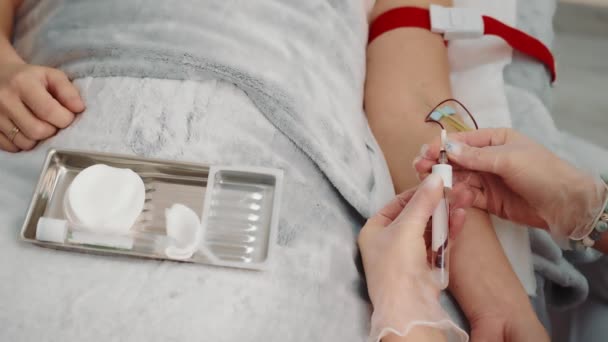 Hemşire hastane koğuşunda yatan bir hastadan kan örneği alıyor. Hücredeki bir hastadan kan örneği.. — Stok video