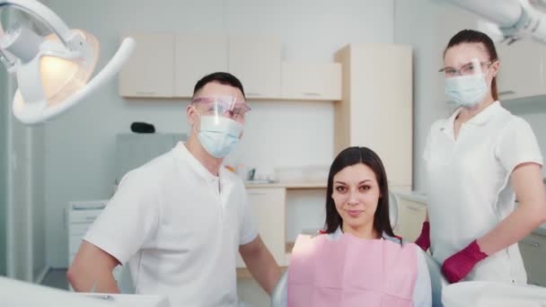 Egy fogászati klinikán dolgozó beteg orvos és asszisztens portréja — Stock videók