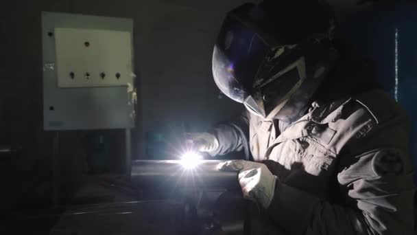 Ein Produktionsarbeiter schweißt Metallstrukturen durch Argon-Schweißen — Stockvideo