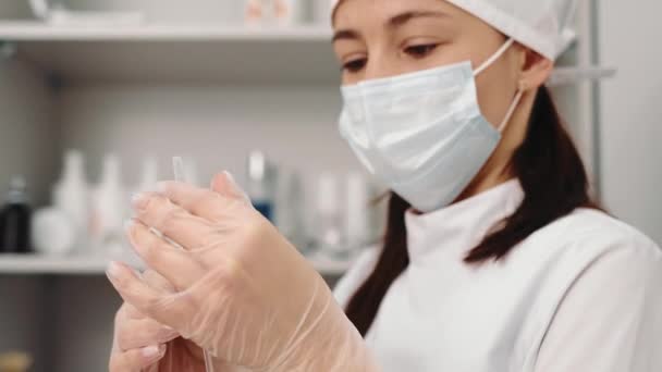 Clinica di bellezza. L'estetista tiene una siringa con Botox per ulteriori iniezioni. Il medico esamina il dispositivo — Video Stock