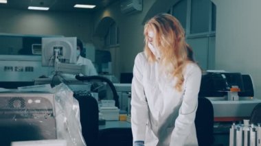 Laboratuvarda deney tüpleri tutan bir araştırmacı. Modern bir laboratuvarda aşı ve kan testleri