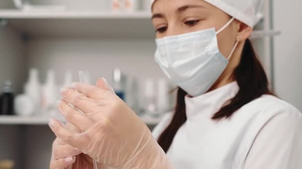 Kosmetická klinika. Kosmetička drží injekční stříkačku s přípravkem Botox pro další injekce. Lékař přístroj vyšetří. — Stock video