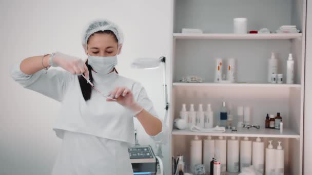 Der Kosmetologe wählt das Medikament in die Spritze, um die Haut zu verjüngen. Hautregeneration mit Injektionen. Moderne Kosmetologie. — Stockvideo