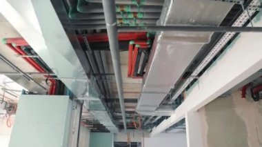 Bina koridorunun tavanındaki borular ve havalandırma. Havalandırma boşluklarının ve su borularının değiştirilmesi ve binanın ısıtılması