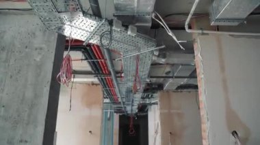 İnşaat alanındaki koridorun tavanından geçen iletişim cihazları..