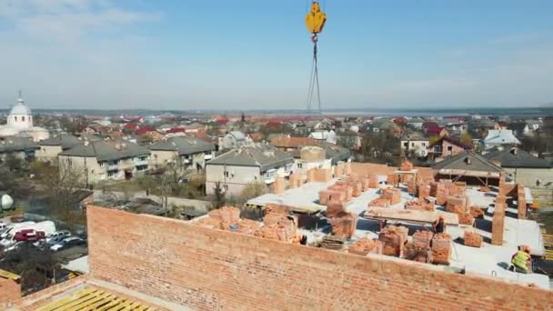 Luchtfoto Bouwkraan levert cement mortel aan de bouwers. Levering van cement op bouwplaats door de bouwkraan — Stockvideo