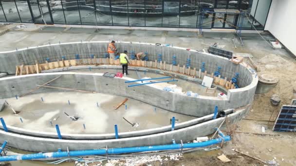 Bassängkonstruktion. en byggarbetsplats där en pool och ett system med fontäner byggs. Rör läggs i marken för att försörja poolen med vatten — Stockvideo