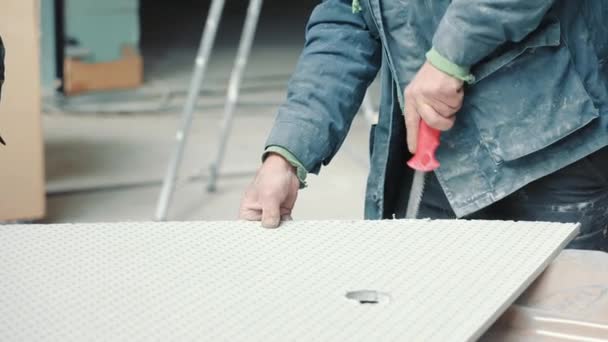 Maestro constructor cortando una forma de paneles de yeso. Un trabajador corta paneles de yeso. — Vídeos de Stock