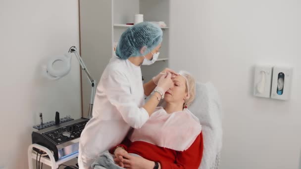 Mezoterápia egy nő arcát egy szépségszalonban. A kozmetológus injekciókat ad be a pácienseknek. Az ajak megnagyobbodásának eljárása, ráncok csökkentése az arcon, bőrfiatalítás — Stock videók