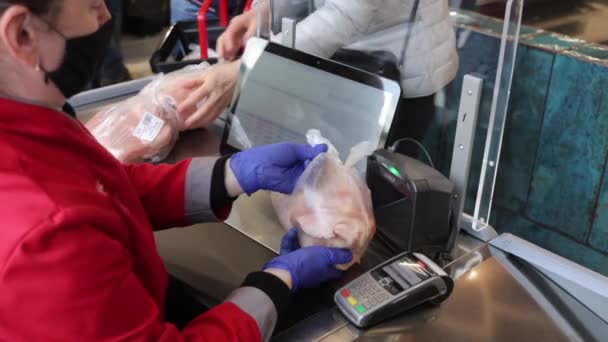Продавец сканирует товар на кассе в супермаркете. закрытие женских рук, сканирующих штрих-код мясной продукции в пластиковом пакете — стоковое видео