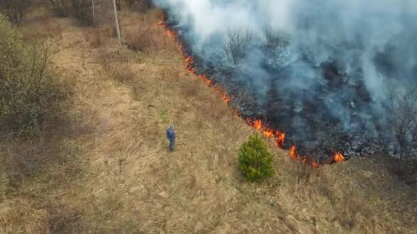 Uomo che guarda il fuoco. Un incendio si avvicinò alle case. Incendio forestale. Erba che brucia. — Video Stock