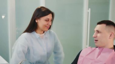 Genç doktor stajyer bir erkek hastayla iletişim kuruyor. Klinikte iki kişinin konuşması