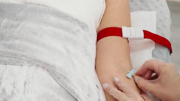 Blutentnahme bei einem kranken Mann aus nächster Nähe im Krankenhaus. Die Krankenschwester durchbohrt den Arm des Patienten mit einer Nadel, um einen Bluttest zu machen. — Stockvideo