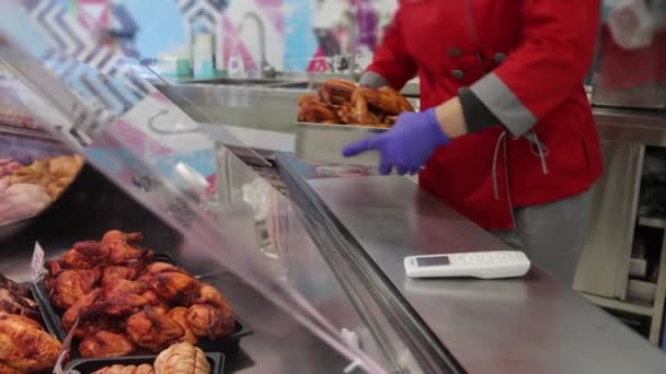 O vendedor coloca uma bandeja de frango fresco assado. Asas de frango em uma janela de loja — Vídeo de Stock