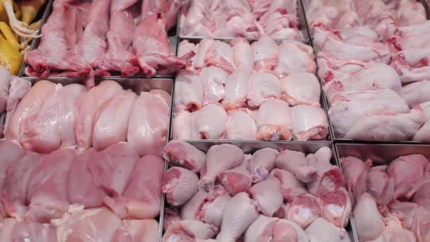 Chicken products on a shop window. Chicken fillet and chicken drumsticks are placed in containers in the window of a supermarket. — Stock Video