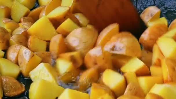 Agiter le yuilba frit avec une planche en bois. Friture de pommes de terre dorées. — Video