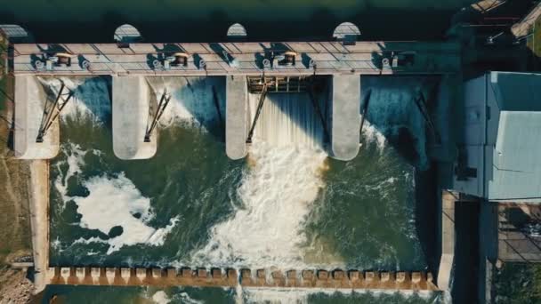 Vue aérienne au sommet d'un petit barrage sur la rivière. Une petite centrale d'importance locale. — Video