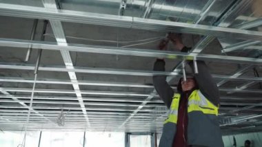 İnşaata tavan kurulumu. Evin ortasında tadilat var. Metal tasarımlardan ağ iskeleti oluşturma