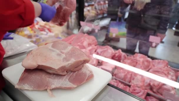 Un pezzo di maiale fresco che il venditore ha preso dal bancone del mercato. — Video Stock