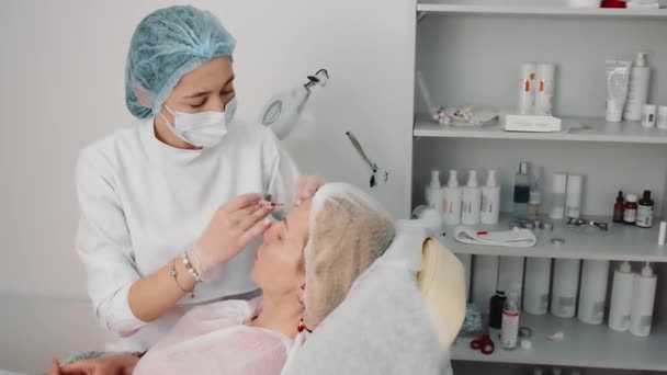 Mesoterapi Närbild. Den kosmetolog gör injektioner i patientens ansikte. Proceduren med läppförstoring, minskning av rynkor i ansiktet, hudföryngring, ansiktslyftning. — Stockvideo