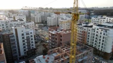 Mahallenin inşaatı. Tuğladan evler inşaat vinci ile yapılır. Yapım aşamasındaki yeni yüksek binaların üzerinden uçmak