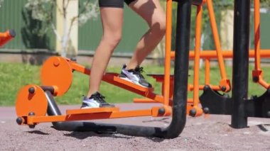 Açık hava sporu, simülatörde koşan kadın. Açık hava sporları. Kadınların bacakları aktif olarak çalışan bir simülatörde hareket ediyor.