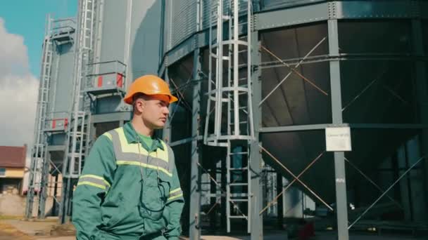 Ingeniero inspeccionando elevadores de almacenamiento de granos. Un empleado de una empresa agrícola inspecciona instalaciones de ascensores. Almacenamiento de cultivos de cereales — Vídeo de stock