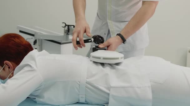 Az orvos lökéshullám-kezelési eljárást hajt végre a betegek újbóli kezelése érdekében. — Stock videók