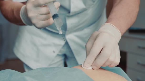 Close-up doctor performs an intramuscular injection in the patients buttocks. — Stock Video