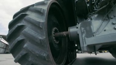 Traktör tekerlekleri ve şanzıman operasyonu. Aşağıdan traktörün görüntüsü. Büyük boyutlu ekipmanların onarımı.