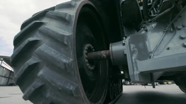 Тракторные колёса и трансмиссия. Вид на трактор снизу. ремонт крупногабаритного оборудования. — стоковое видео