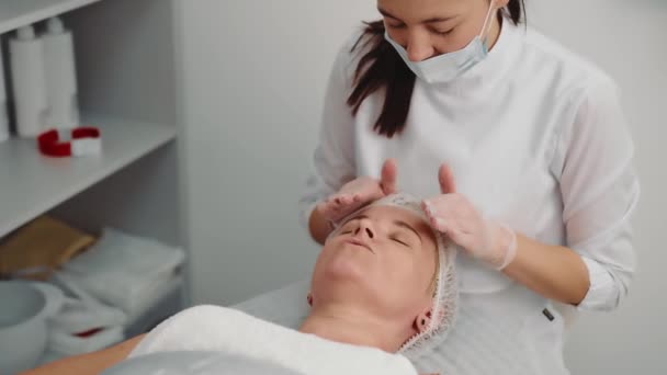 Lymphatic drainage technique. old woman enjoying facial massage. Beauty treatments in the spa. Wellness and beauty salon. Relaxing and health. Woman enjoying a relaxing facial massage. — Stock Video