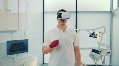 Genç bir dişçi, VR gözlüklerinin yardımıyla en son diş teknolojisine bakıyor. Geleceğin dişçiliği.