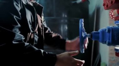 Bir mühendisin elleri hızla büyük bir endüstriyel vinci döndürüyor. Su veya gaz tedariği çakışması.