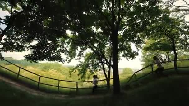 Silhouet Het runnen van twee meisjes in het park, zijaanzicht, ochtend joggen van twee atleten, uitzicht op de stad, rennen in de buurt van het vlot, het runnen van twee tienermeisjes op de achtergrond van de stad — Stockvideo