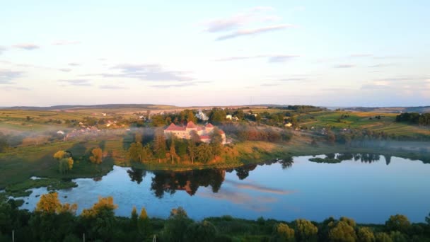 Vackert landskap: ett slott vid sjön i ett pittoreskt hörn. Forntida slott i parken vid solnedgången. Fantastiskt slott, himmel och natur och deras reflektion i sjön — Stockvideo