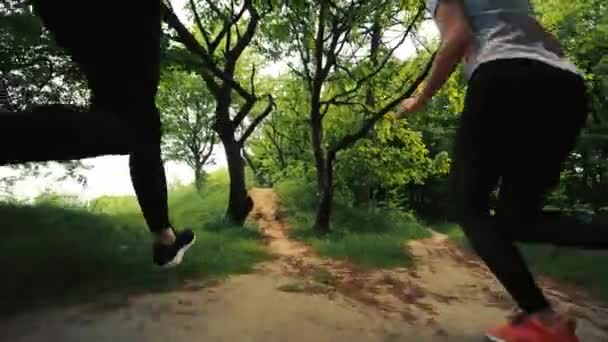 Dos chicas corriendo por un sendero forestal, corriendo dos chicas jóvenes, vista trasera, chicas corriendo por la mañana, corriendo dos atletas — Vídeo de stock