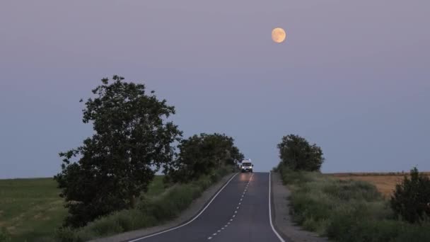 Ambulância viajando à noite na estrada para a aldeia. Ambulância com faróis em — Vídeo de Stock