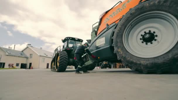 Ukraine, Lviv. 15.08.2021 L'agriculteur ouvre le couvercle du pulvérisateur de champ. Remplissage du tracteur avec une solution chimique pour pulvériser les champs. — Video