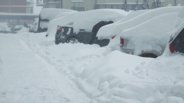 Seorang pria membersihkan mobilnya dari salju. Membersihkan tempat parkir untuk salju dari salju dengan sekop. — Stok Video