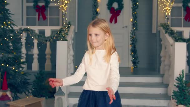 Küçük kız büyük bir kutuda bir hediye yakalar. Kız aldığı hediyeyle sevinir. Noel hediyesi — Stok video