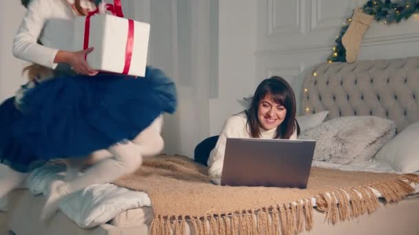 Mamá feliz con los niños el día de Navidad mostrando regalos a papá a través de la computadora portátil. Videollamada con familia y niños felices con regalos en la noche de Navidad. — Vídeos de Stock