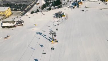 Kışın kayak merkezi. Kayakçıları kaldıran asansör. Kayak yamacının üzerinden uçmak.